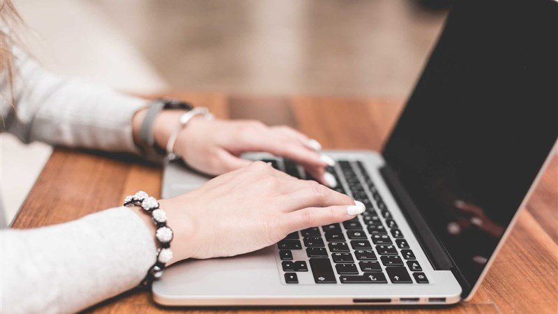 Hands Working on a Laptop Keys