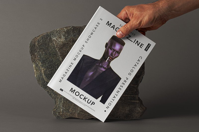 free hand holding magazine mockup stone background